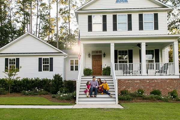 Family sitting on steps in front of home